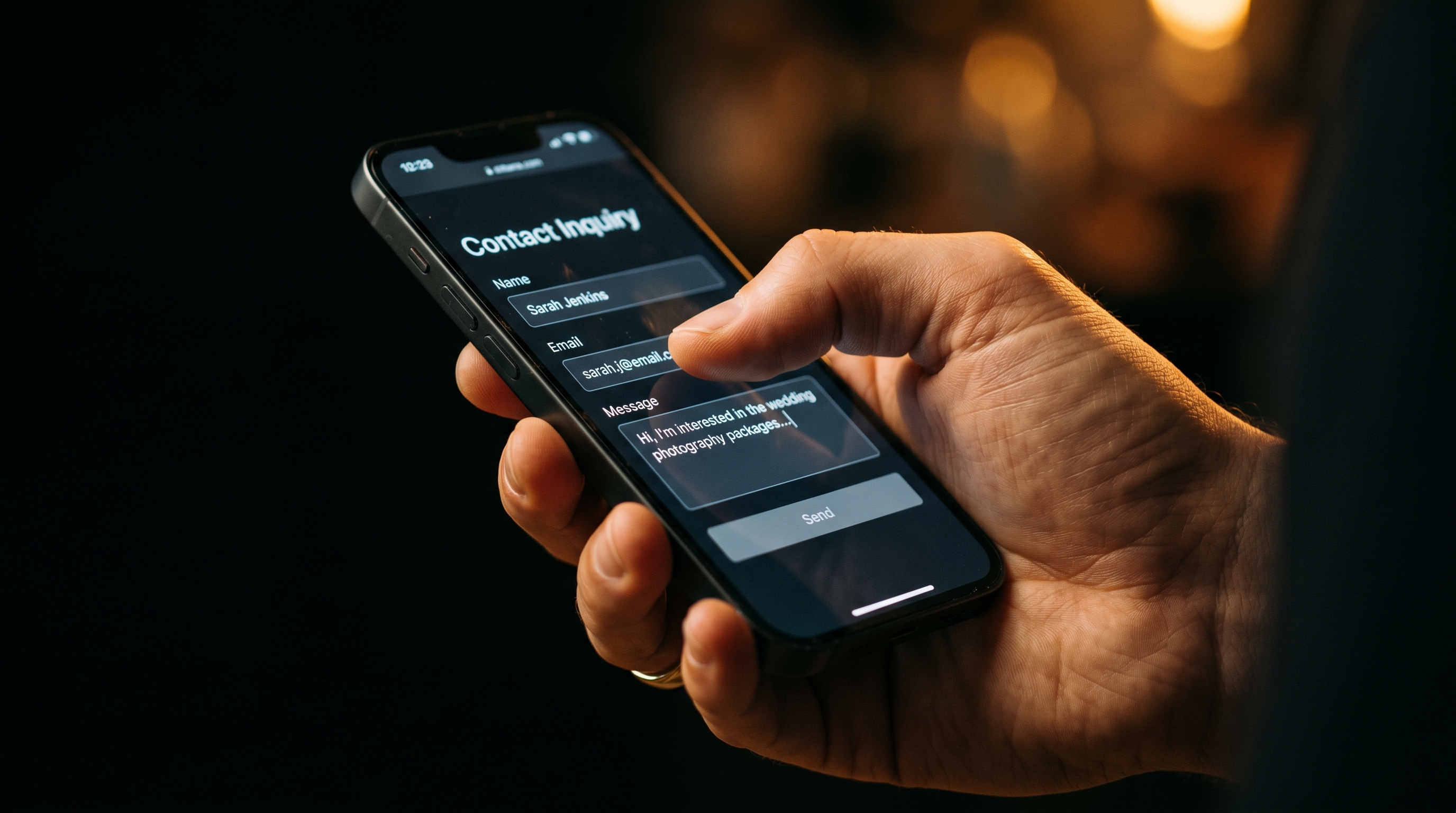 Hand holding an iPhone showing a contact inquiry form